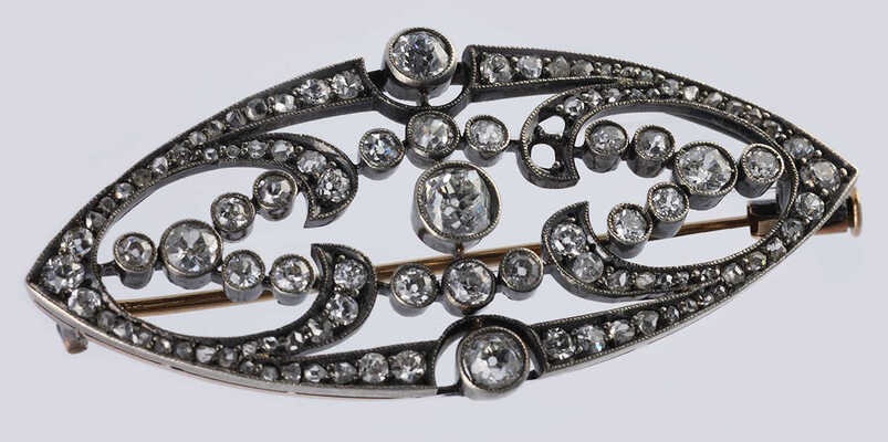 Брошь из желтого и белого металла, общим весом 7,82 грамма, содержит природные вставки из бриллиантов